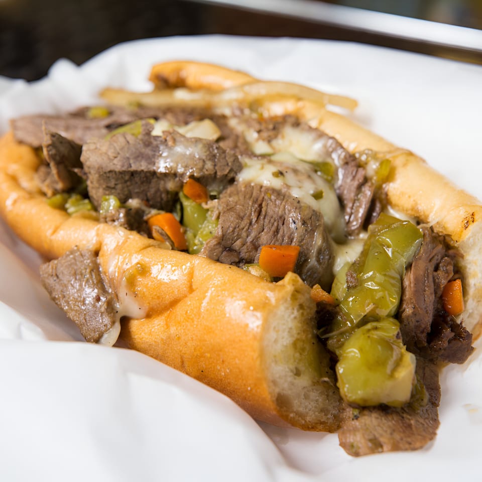 Badda Bing's Italian Beef sandwich, loaded with meat, melted cheese, and green and orange peppers.